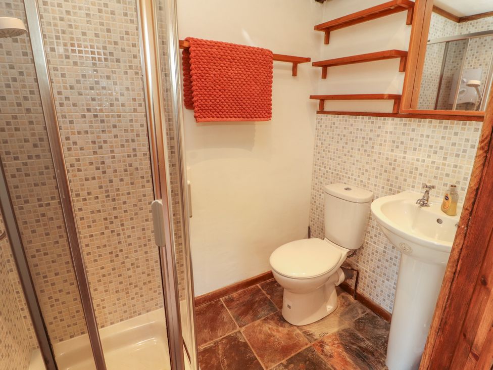 A bathroom with a shower, toilet, and sink at Beck Edge in Braithwaite