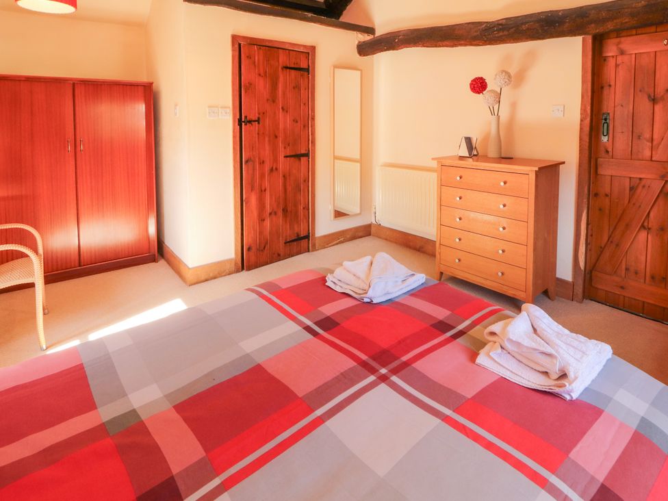 A bedroom with a bed, wardrobe, and dresser at Beck Edge in Braithwaite