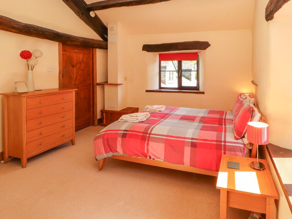 A bedroom with a bed and dresser at Beck Edge in Braithwaite