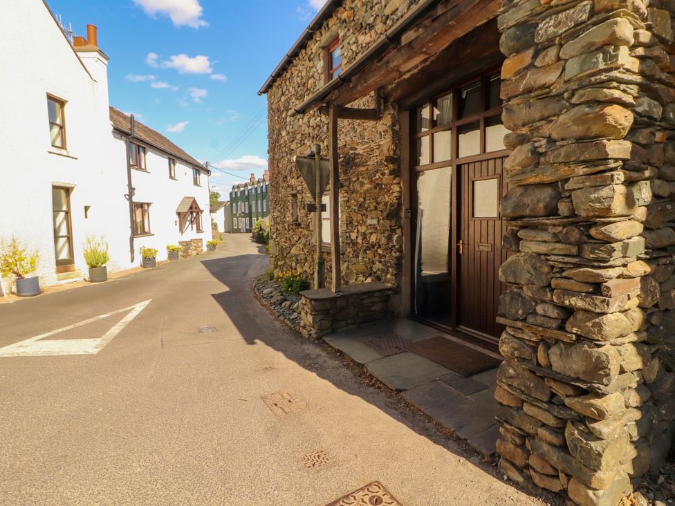A view of a stone building and road in Braithwaite at Beck Edge
