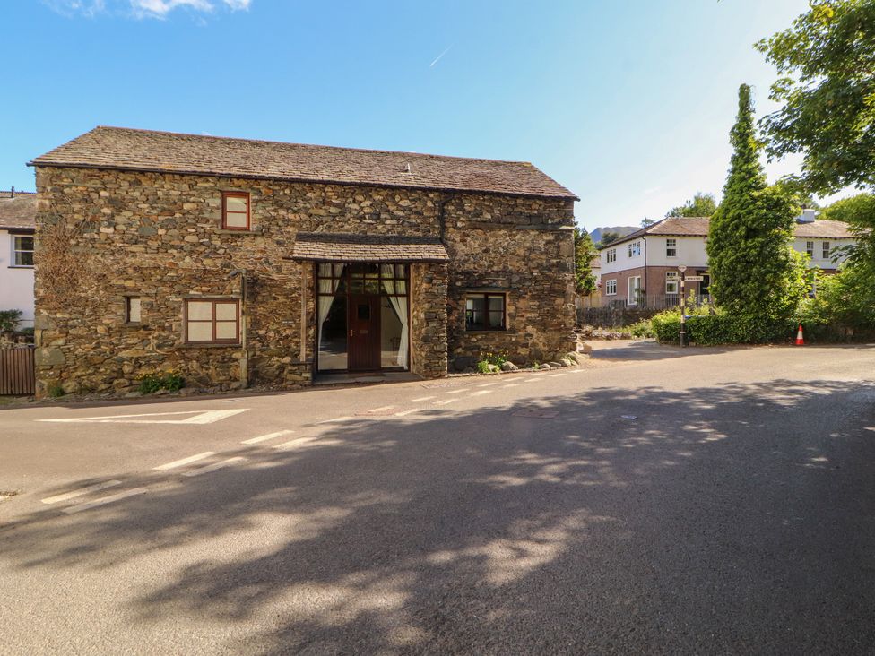 A stone building with windows and a door at Beck Edge in Braithwaite