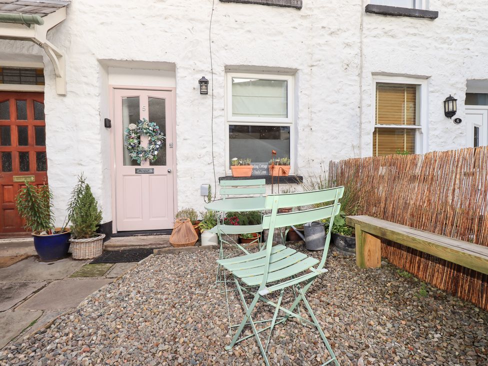 A doorway with a wreath and chairs in front at Gosling Cottage in Kendal
