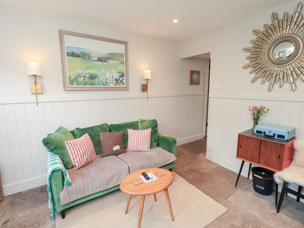 A living room with a sofa and table at Gosling Cottage in Kendal