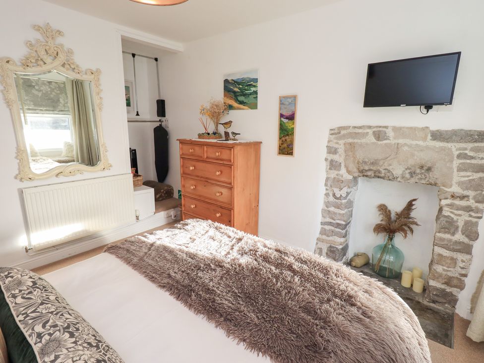 A bedroom with a mirror and wardrobe at Gosling Cottage in Kendal
