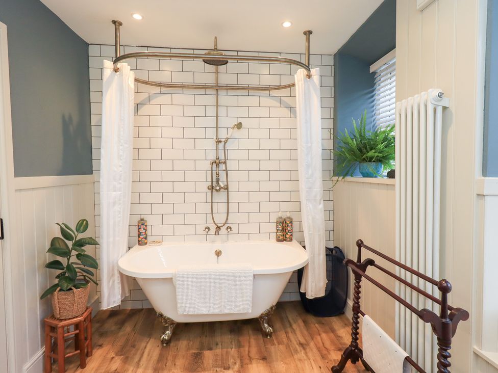A bathroom with a bathtub and shower in Gosling Cottage Kendal