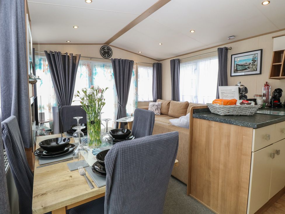 A living room with a dining table and sofa at Seashell Lodge, 50 Foxburrow Hang in Belton, Norfolk