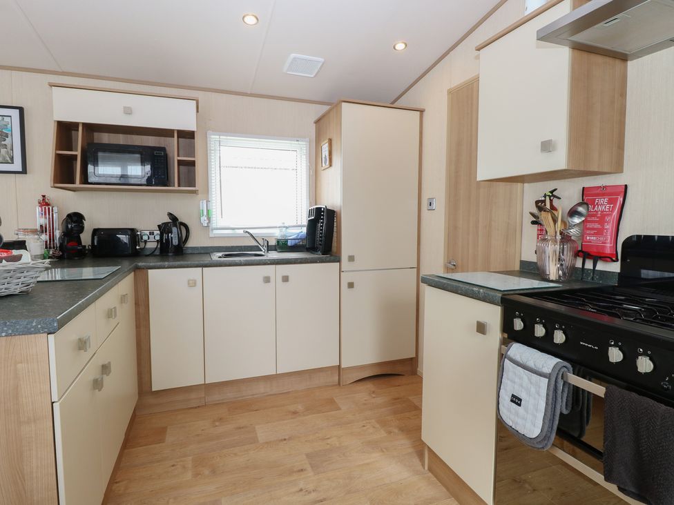 A kitchen with modern appliances and cabinetry at Seashell Lodge, 50 Foxburrow Hang, Belton, Norfolk