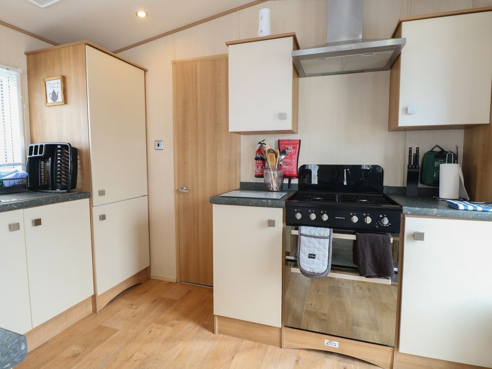 A kitchen with cabinets and an oven at Seashell Lodge, 50 Foxburrow Hang in Belton, Norfolk