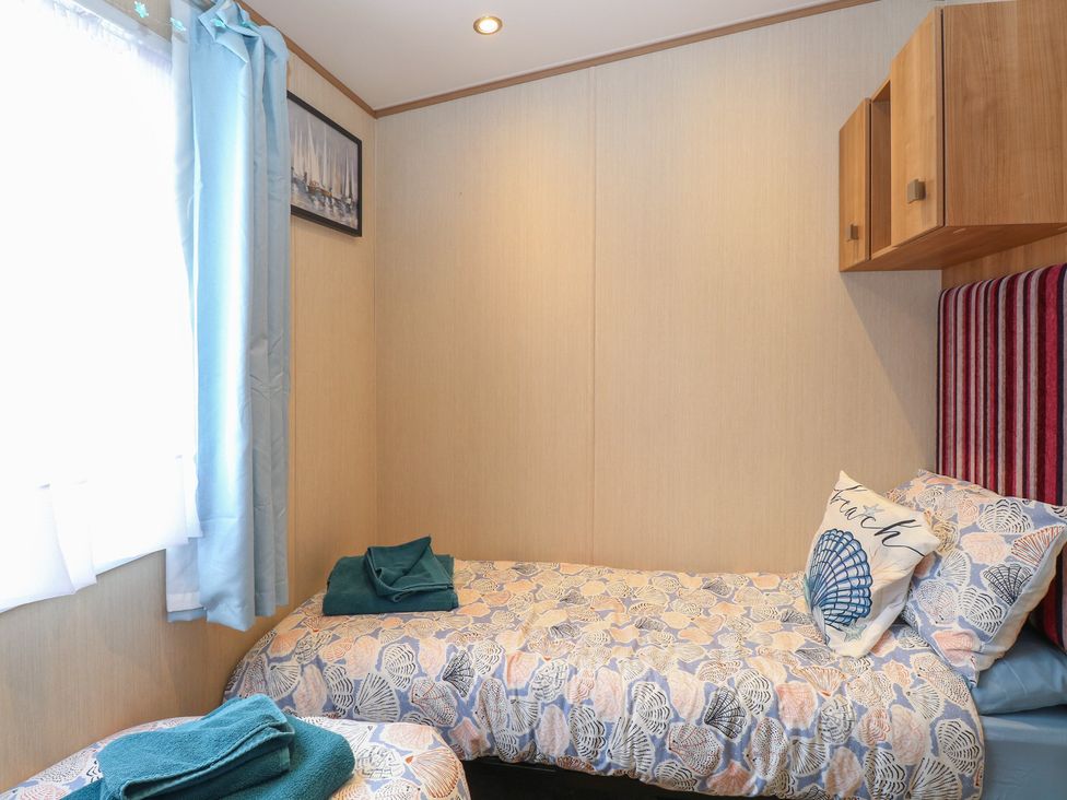 A bedroom with two beds and a shelf at Seashell Lodge, 50 Foxburrow Hang, Belton, Norfolk