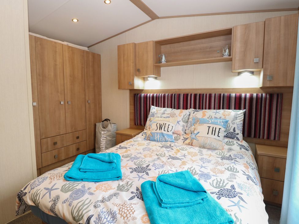 A bedroom with a bed and furniture at Seashell Lodge, 50 Foxburrow Hang Belton, Norfolk