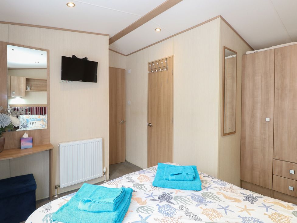 A bedroom with a bed and television at Seashell Lodge, 50 Foxburrow Hang Belton, Norfolk
