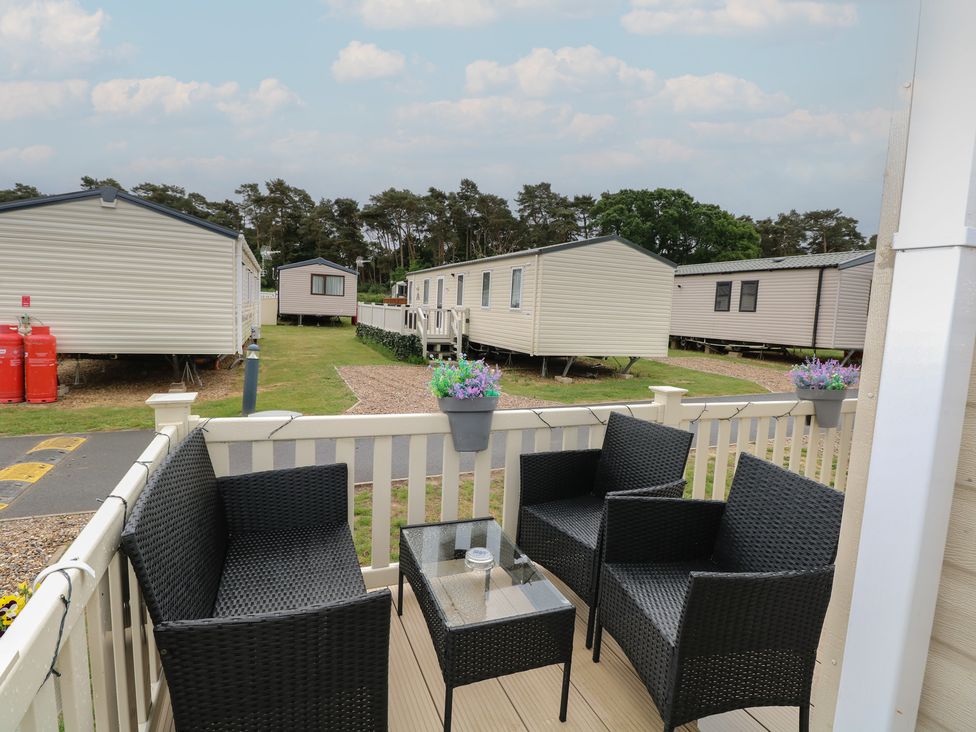 An outdoor seating area with chairs and a table at Seashell Lodge, 50 Foxburrow Hang in Belton, Norfolk