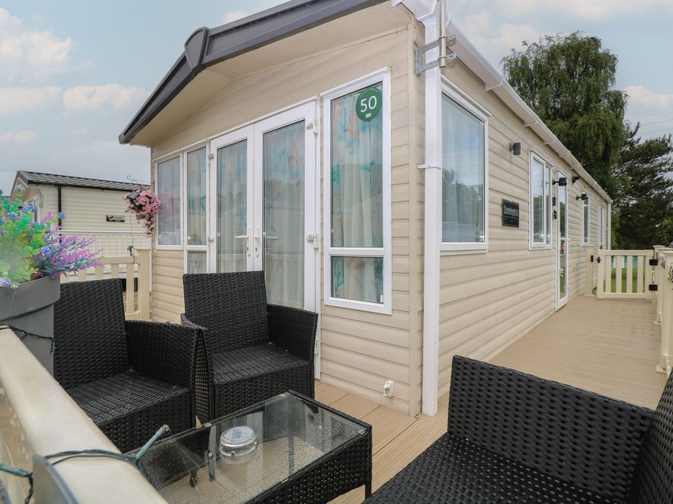 An outdoor area with seating and a table at Seashell Lodge, 50 Foxburrow Hang, Belton, Norfolk