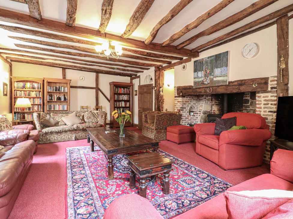 A living room with a fireplace and bookshelves at Chilton Manor House in Sittingbourne