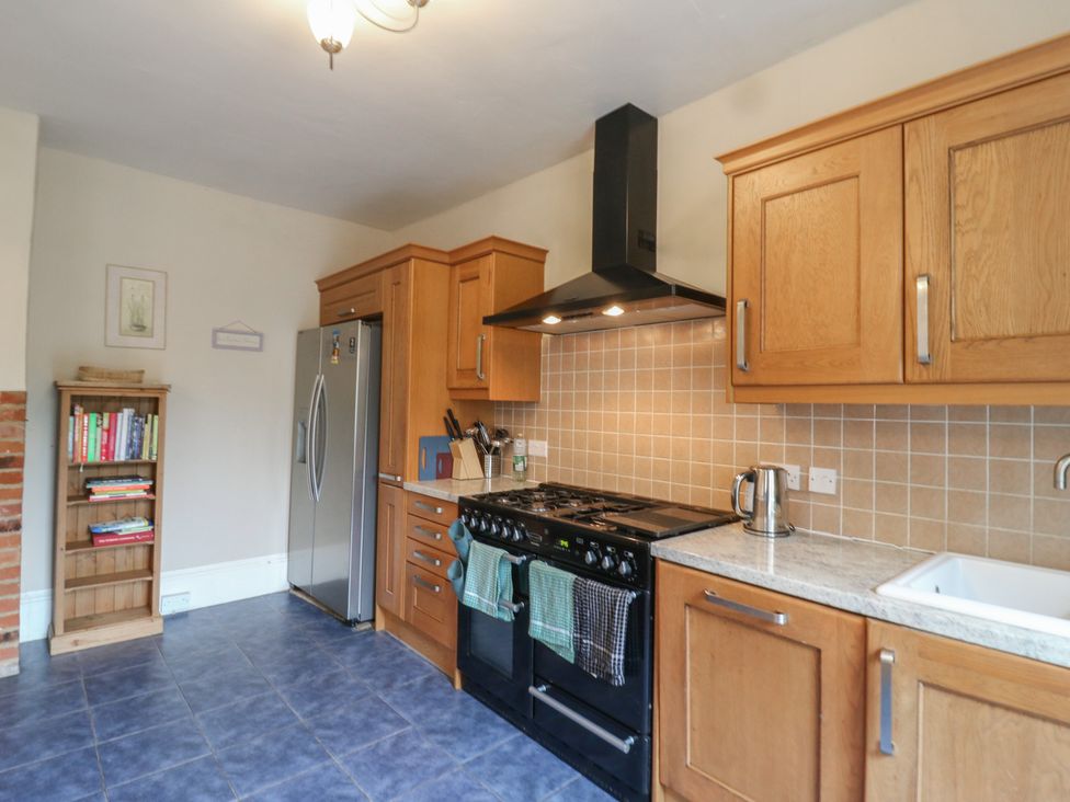 A kitchen with a stove and refrigerator at Chilton Manor House in Sittingbourne