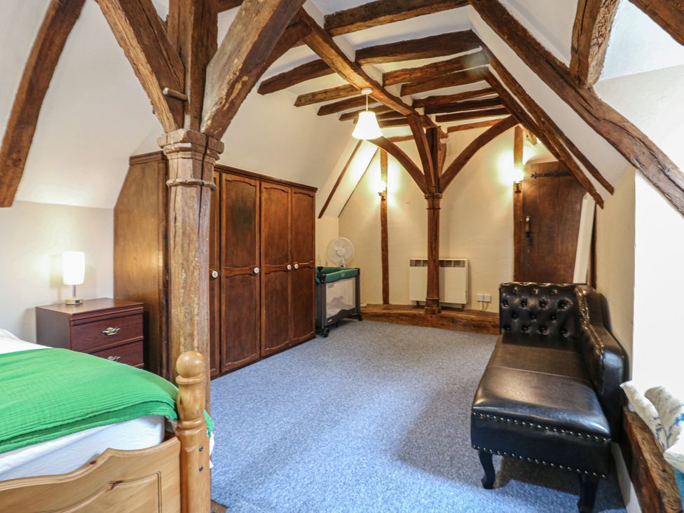 A bedroom with a bed and wardrobe at Chilton Manor House Sittingbourne