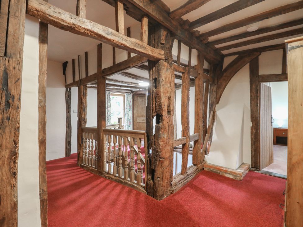A hallway with wooden beams and a staircase at Chilton Manor House in Sittingbourne