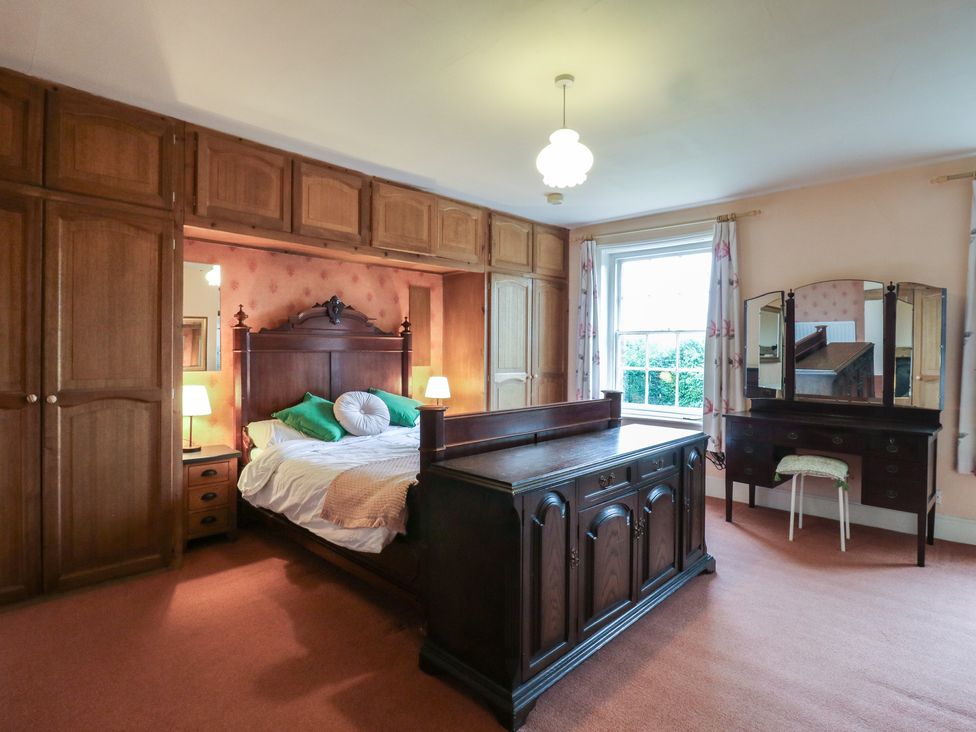 A bedroom with a bed and dresser at Chilton Manor House in Sittingbourne
