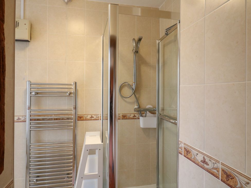 A bathroom with a shower and towel rail at Chilton Manor House in Sittingbourne