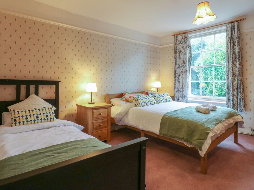 A bedroom with two beds and a window at Chilton Manor House in Sittingbourne