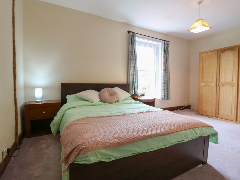 A bedroom with a bed and a wardrobe at Chilton Manor House in Sittingbourne
