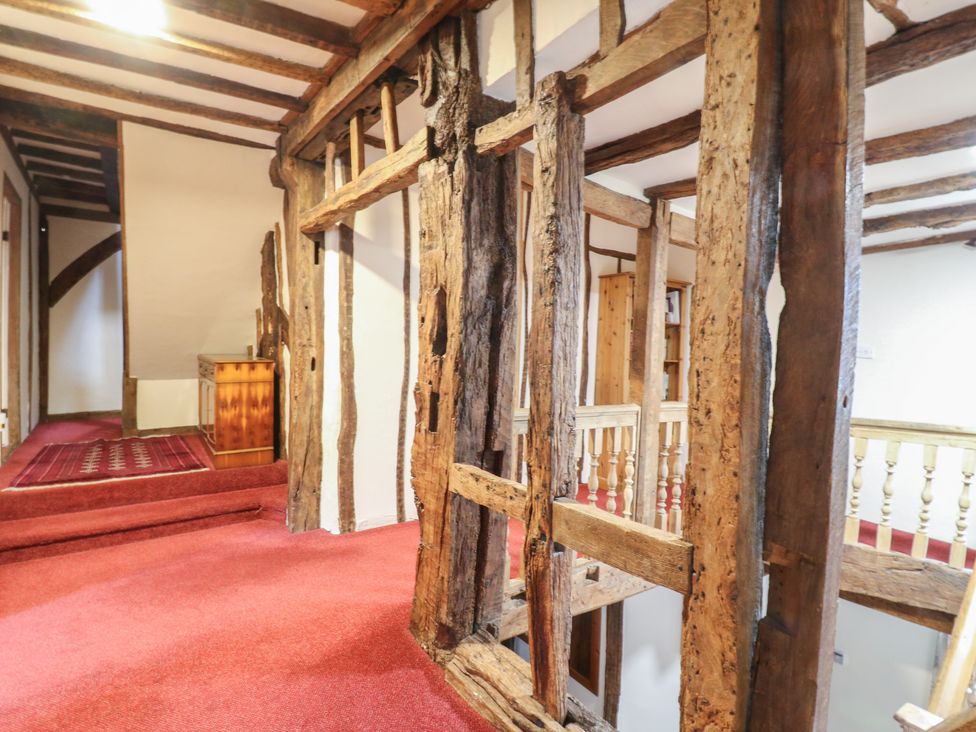 A hallway with wooden beams and carpet at Chilton Manor House in Sittingbourne