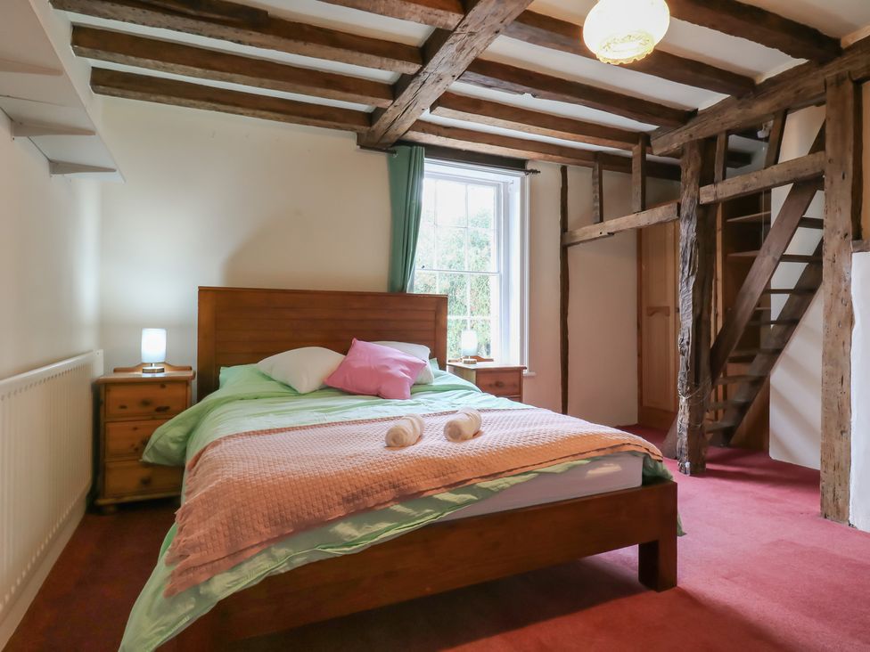 A bedroom with a bed and a staircase at Chilton Manor House in Sittingbourne