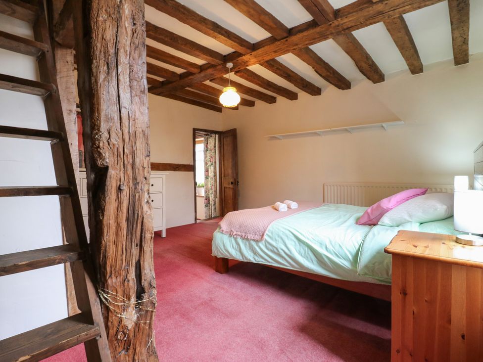 A bedroom with a bed and a dresser at Chilton Manor House in Sittingbourne