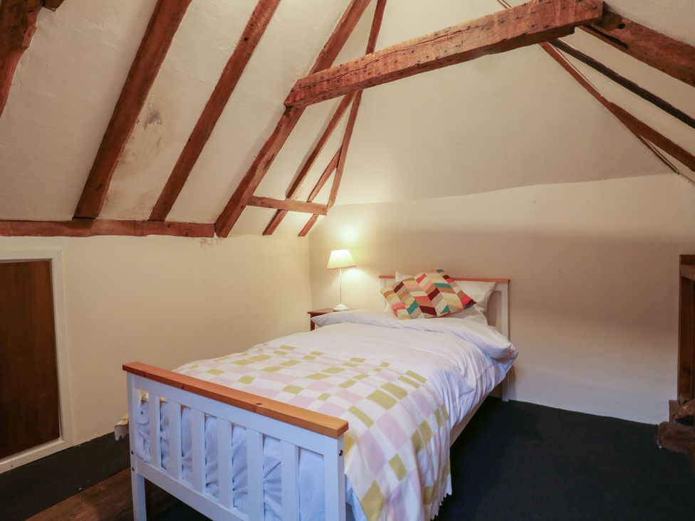 A bedroom with a bed and a bedside table at Chilton Manor House in Sittingbourne