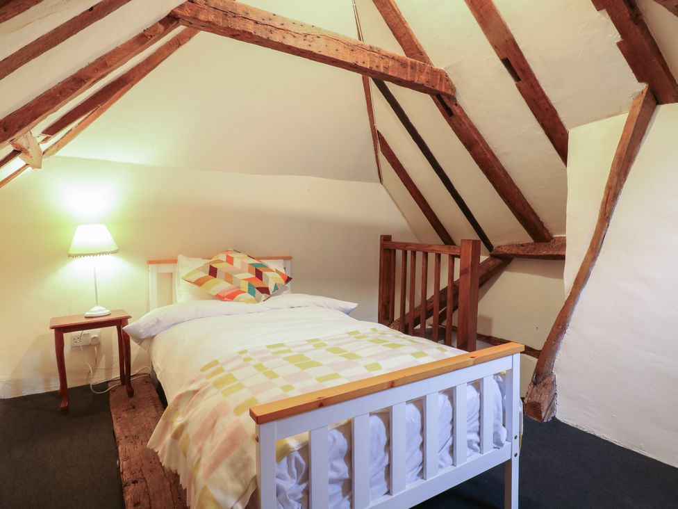 A bedroom with a bed, lamp, and nightstand at Chilton Manor House Sittingbourne