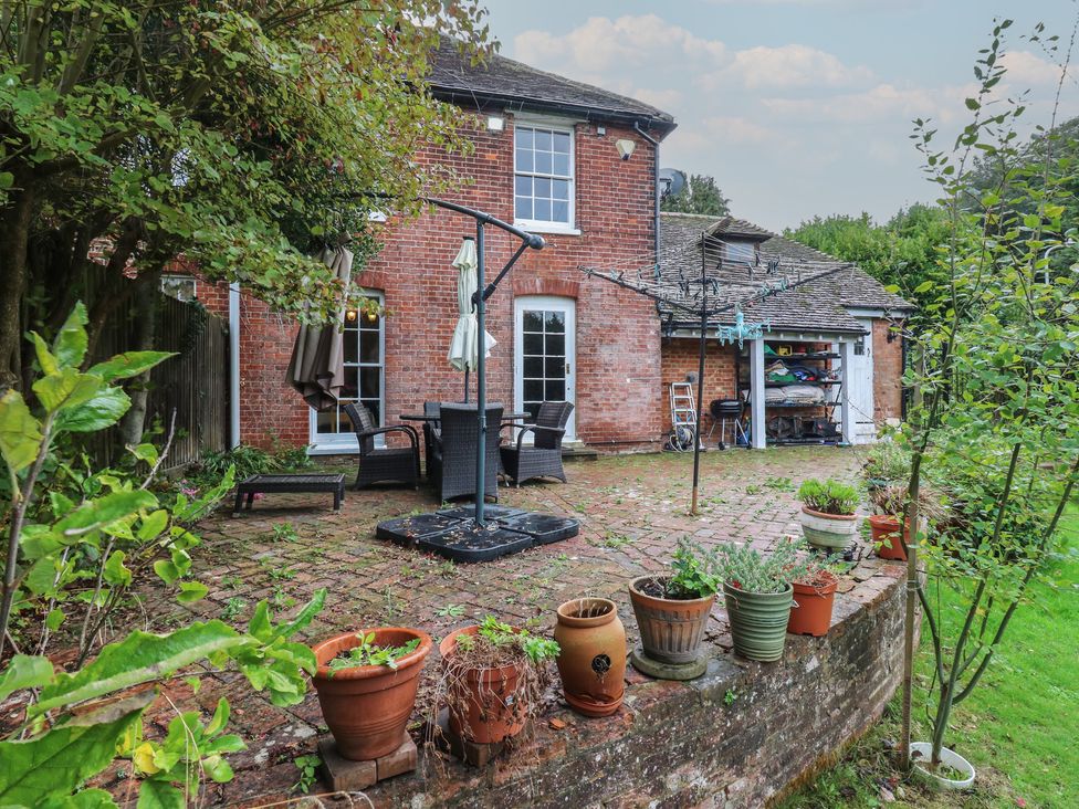 A garden with patio furniture and planters at Chilton Manor House in Sittingbourne