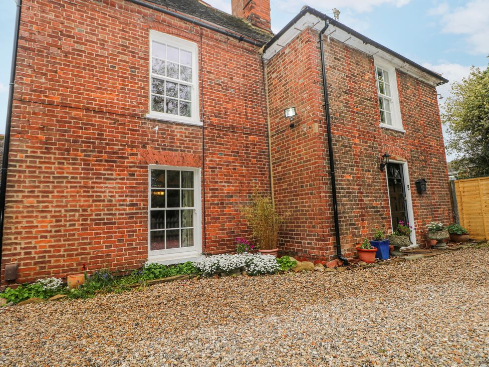 An exterior view of a brick house with windows and flower pots at Chilton Manor House in Sittingbourne