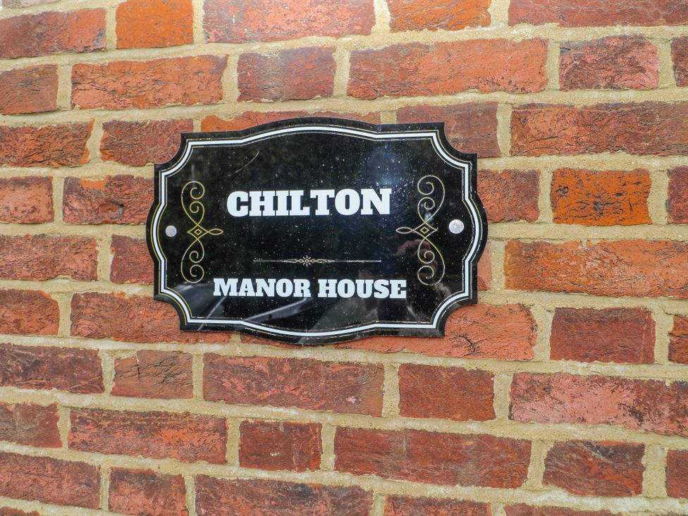 A sign displaying 'Chilton Manor House' on a brick wall at Chilton Manor House in Sittingbourne