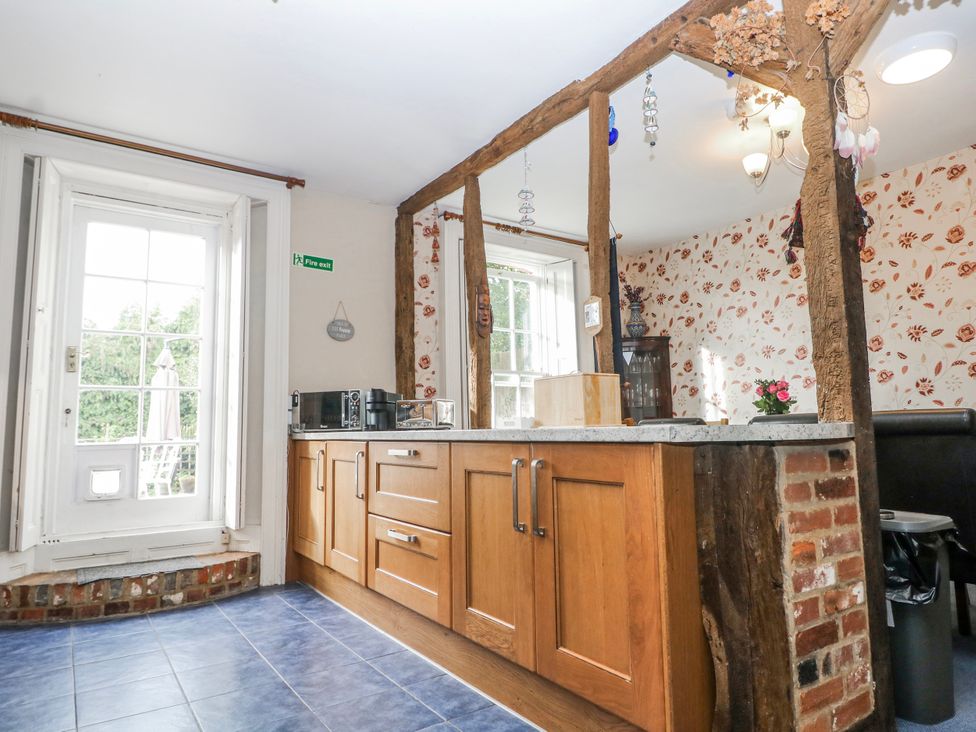 A kitchen with wooden beams and appliances at Chilton Manor House in Sittingbourne