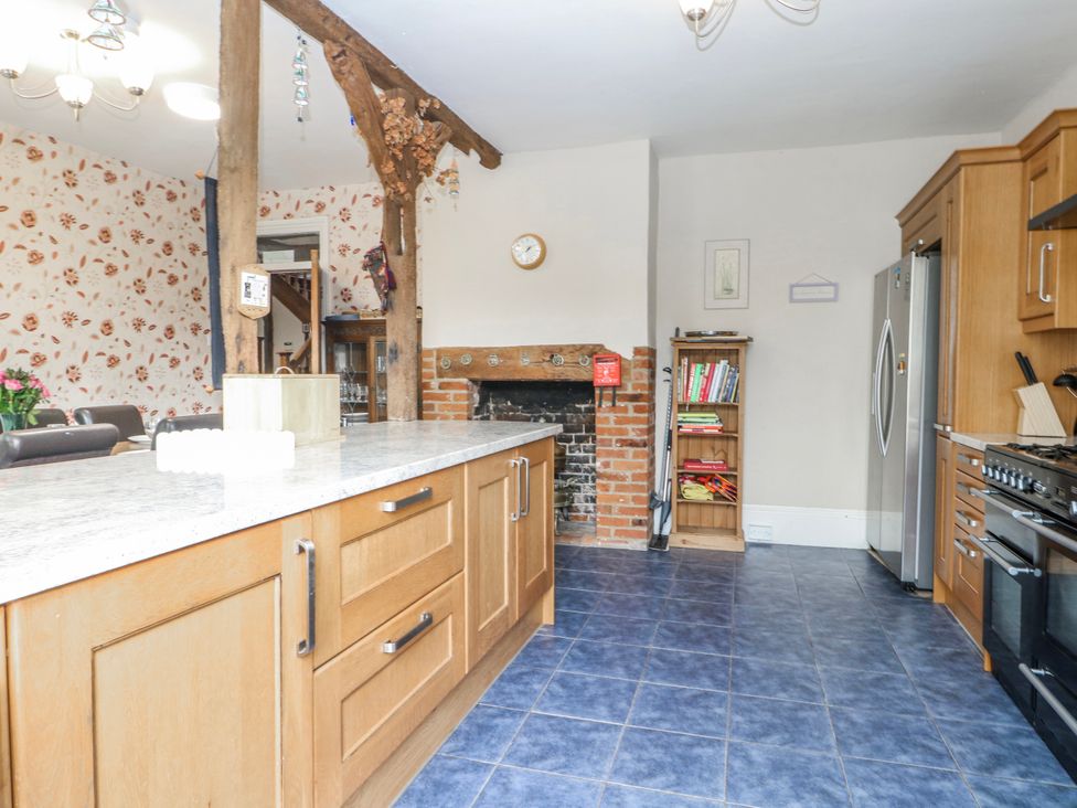 A kitchen with a large island and a fireplace at Chilton Manor House in Sittingbourne