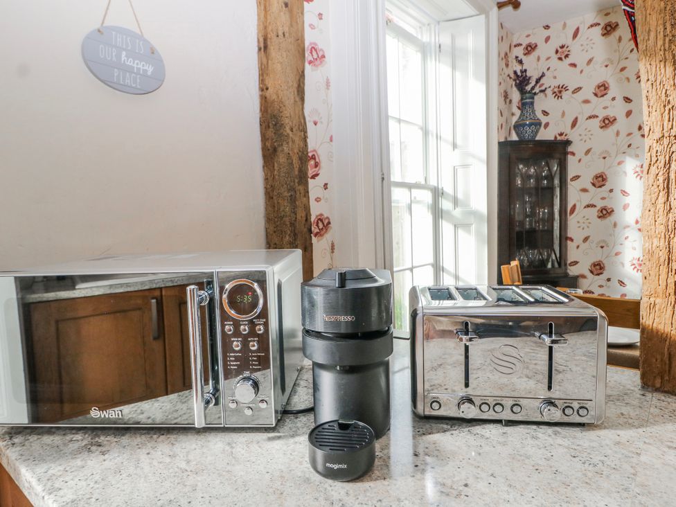 A kitchen with a microwave coffee maker and toaster at Chilton Manor House Sittingbourne