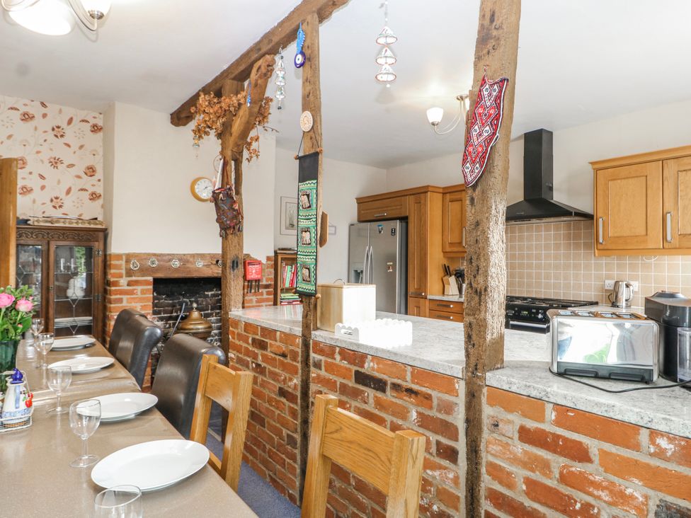 A kitchen with wooden beam, table and chairs at Chilton Manor House in Sittingbourne