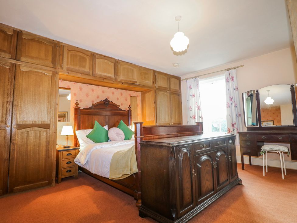 A bedroom with a bed and wardrobe at Chilton Manor House in Sittingbourne