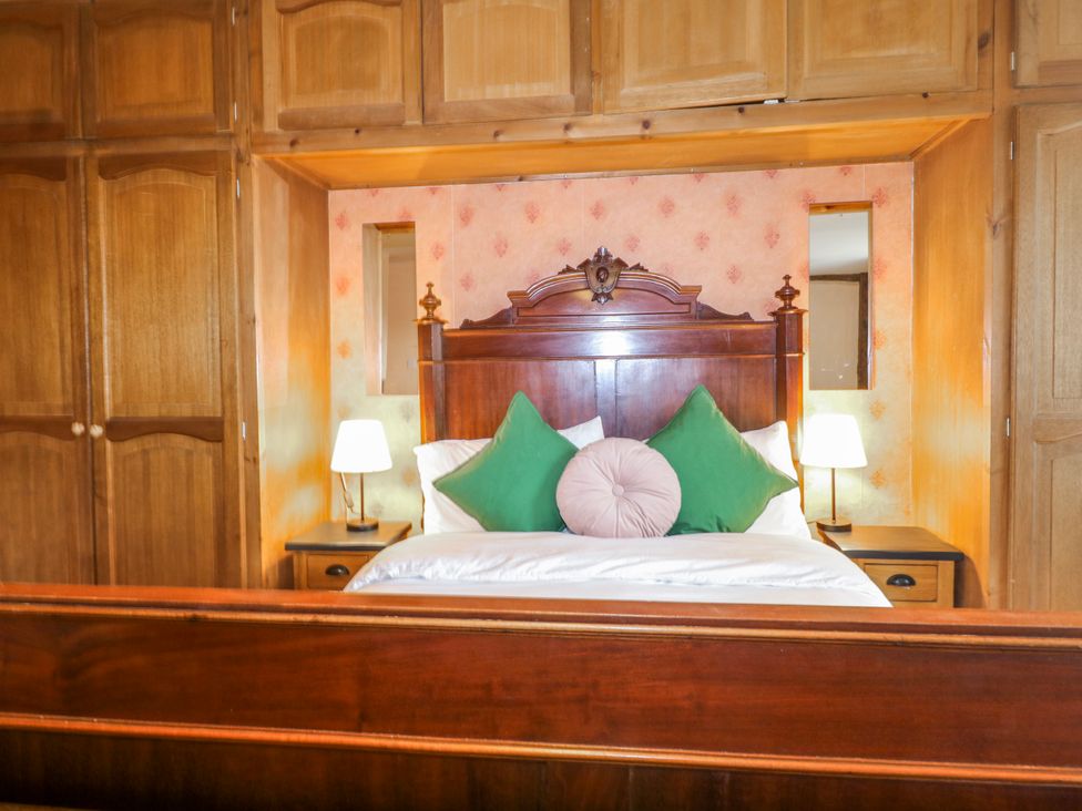 A bedroom with a bed and wardrobe at Chilton Manor House in Sittingbourne