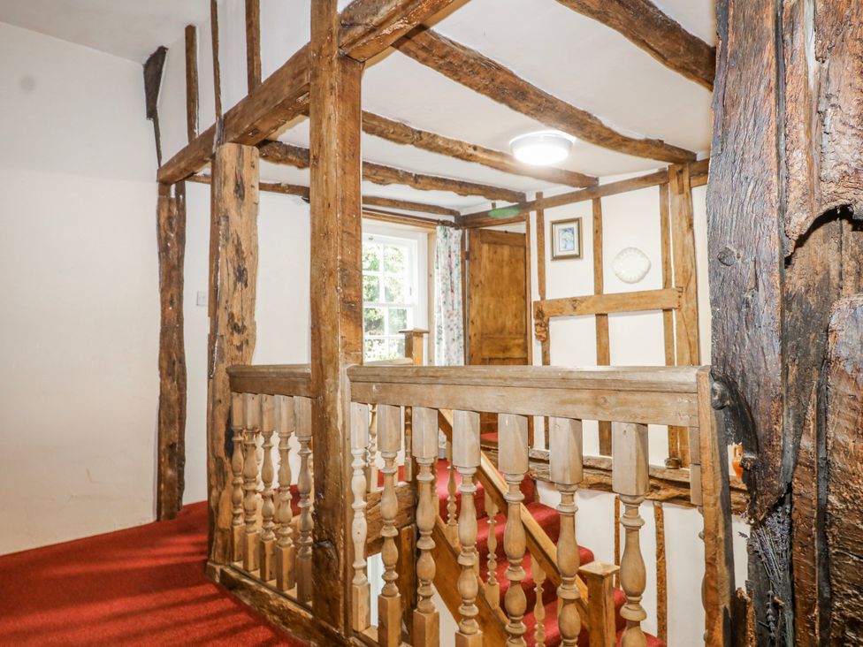 A hallway with wooden beams and a staircase at Chilton Manor House in Sittingbourne