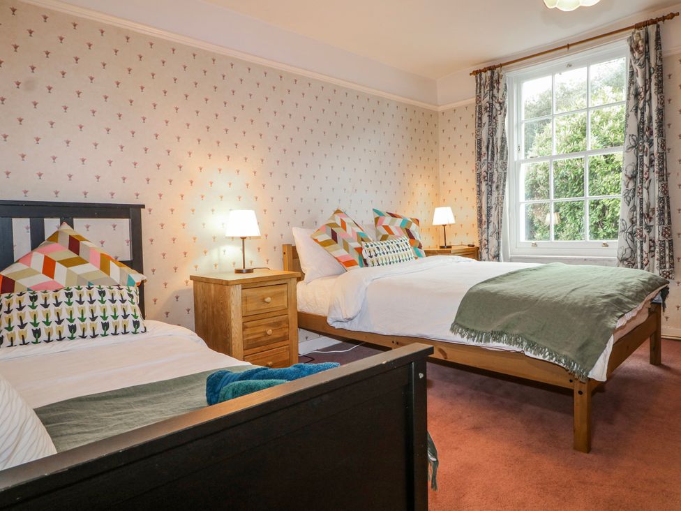 A bedroom with two beds and a window at Chilton Manor House in Sittingbourne
