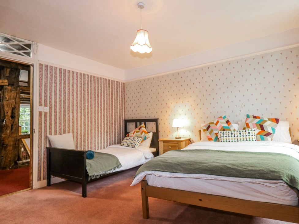 A bedroom with two beds and a bedside lamp at Chilton Manor House in Sittingbourne