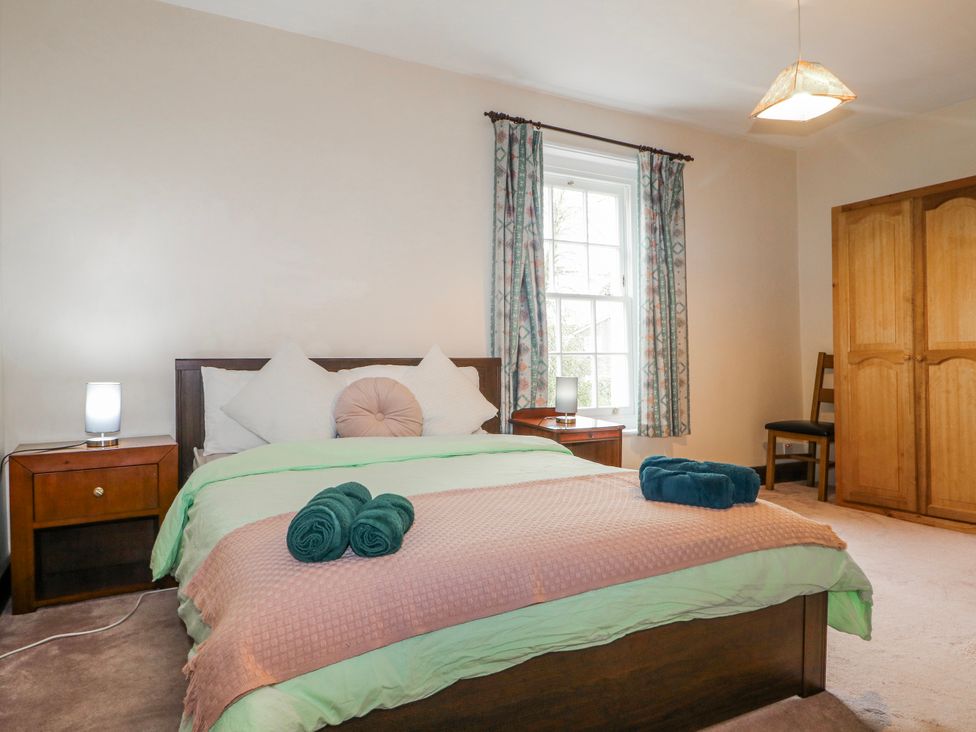 A bedroom with a bed and wardrobe at Chilton Manor House in Sittingbourne