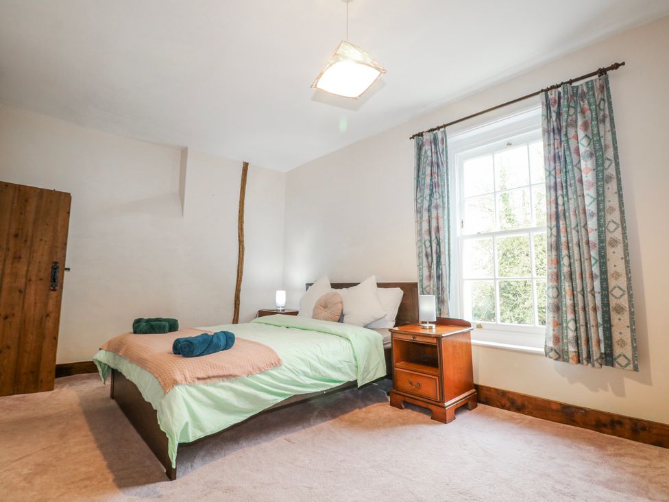A bedroom with a bed and bedside table at Chilton Manor House in Sittingbourne