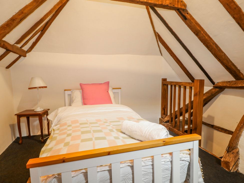 A bedroom with a bed and bedside table at Chilton Manor House in Sittingbourne