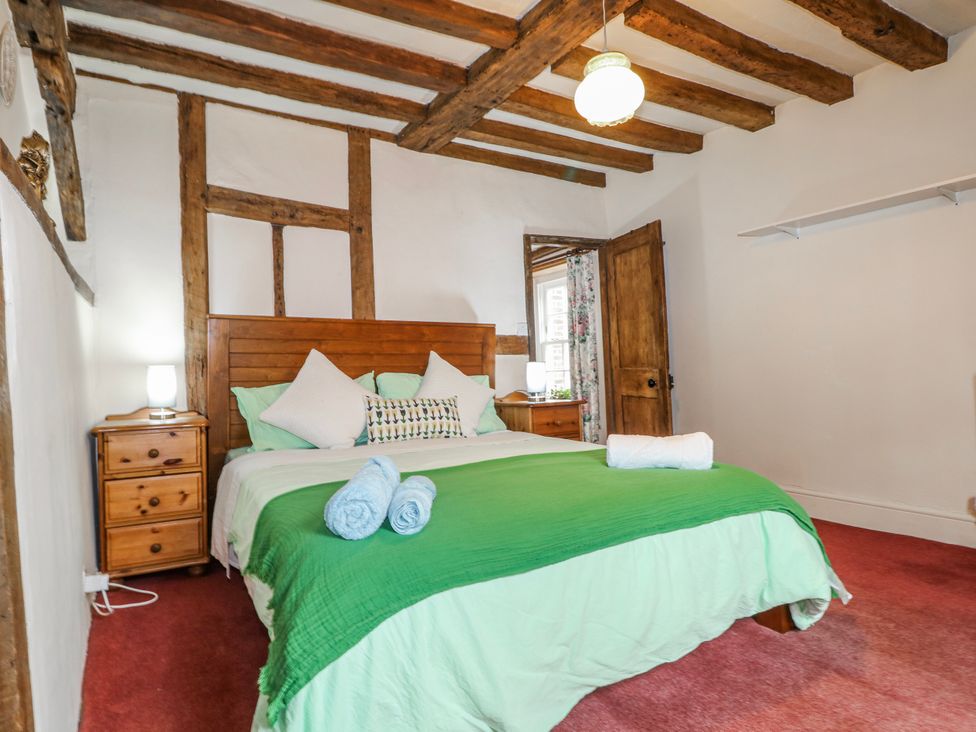 A bedroom with a bed and wooden furniture at Chilton Manor House in Sittingbourne