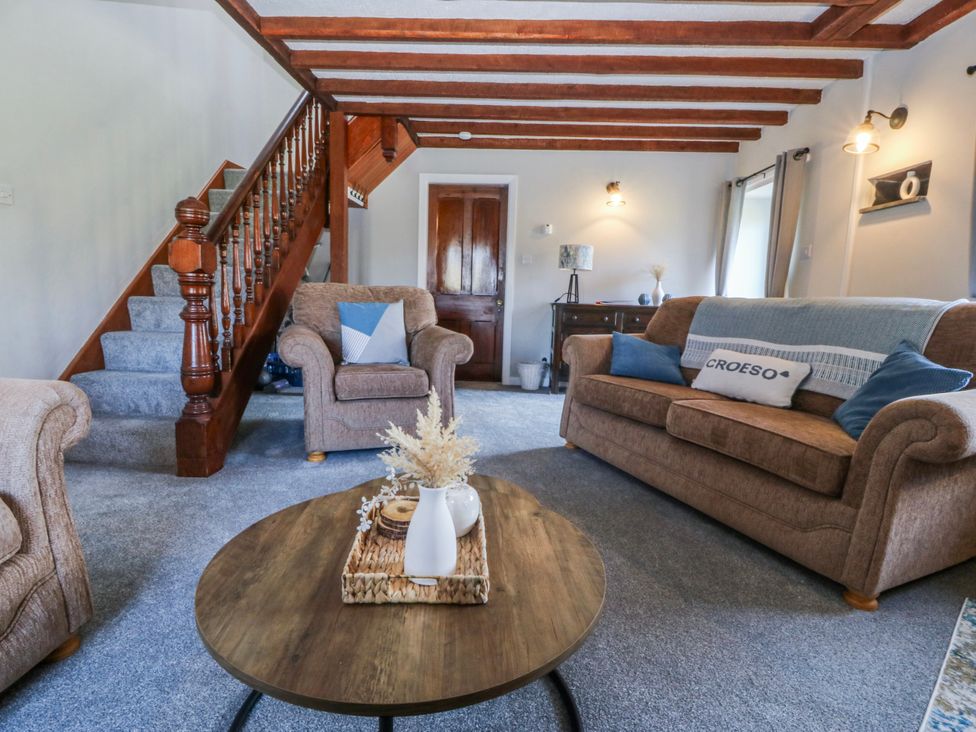 A living room with a sofa and coffee table at Bwthyn Derwin Fawr near Garndolbenmaen