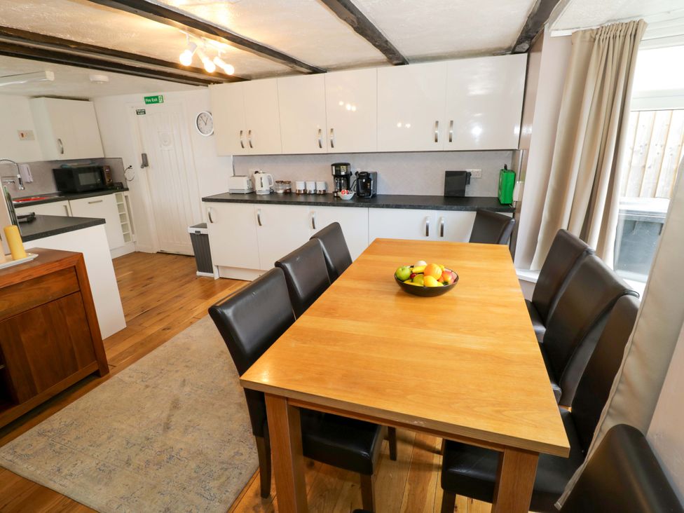 A kitchen with a dining table and chairs at The Golden Cross Cottage in Evesham