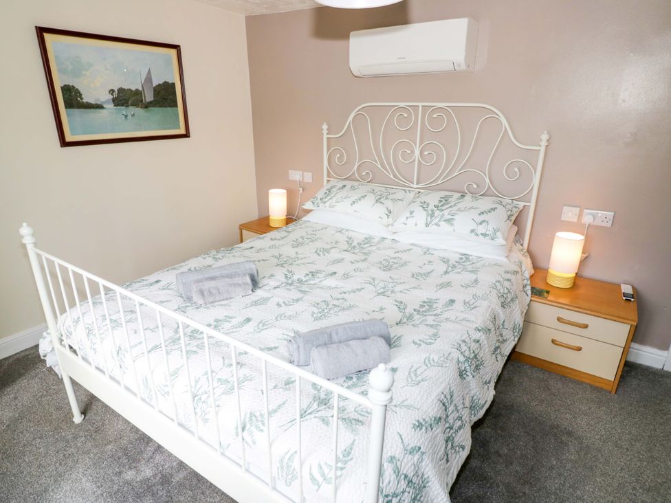 A bedroom with a bed and bedside table at The Golden Cross Cottage Evesham