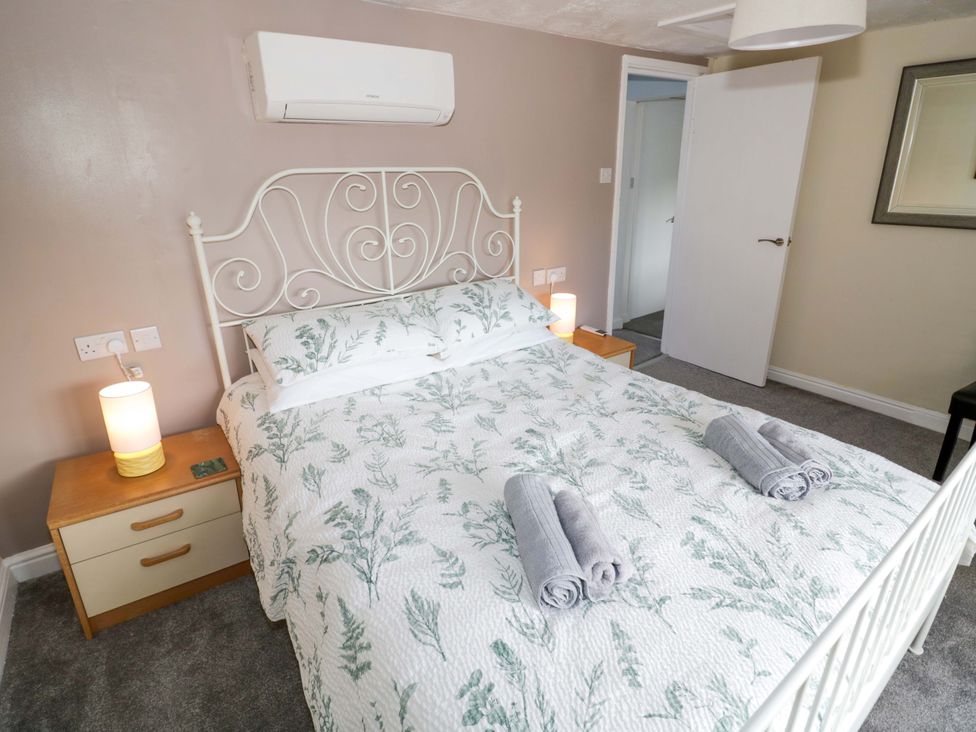 A bedroom with a bed and bedside table at The Golden Cross Cottage in Evesham